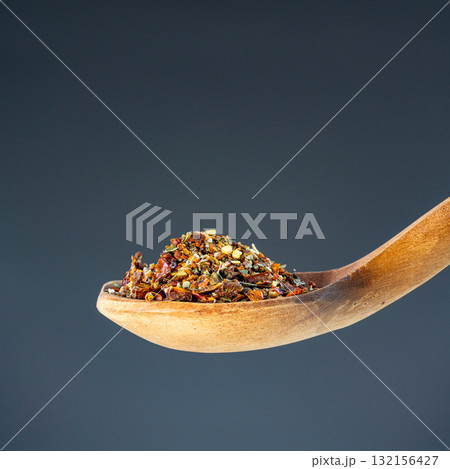 Aromatic spice mixture piled on rustic wooden utensil, great for gourmet cooking and flavor enhancement themes 132156427