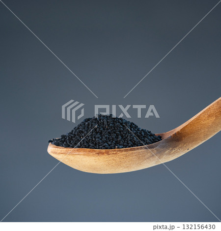 Dark nigella seeds in natural wood spoon, ideal for spice, seasoning and exotic recipe preparation concepts 132156430
