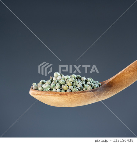 Organic green peppercorns arranged on wooden spoon, ideal for seasoning, cooking and culinary ingredient imagery Organic green peppercorns arranged on wooden spoon, ideal for seasoning, cooking and culinary ingredient imagery 132156439