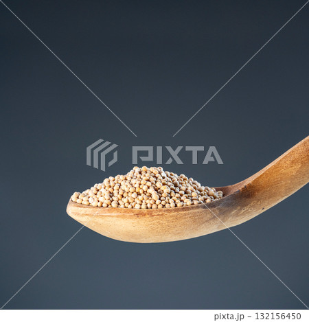 Dried whole pepper seeds displayed in rustic wood ladle, ideal for cooking ingredients and organic food photography Dried whole pepper seeds displayed in rustic wood ladle, ideal for cooking ingredients and organic food photography 132156450