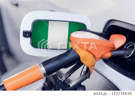The Nigeria flag on the lid of the gas tank of a car at a gas station in close-up. High or low prices for gasoline and diesel fuel at Nigerian gas stations. Problems with the quality of gasoline and 132156638