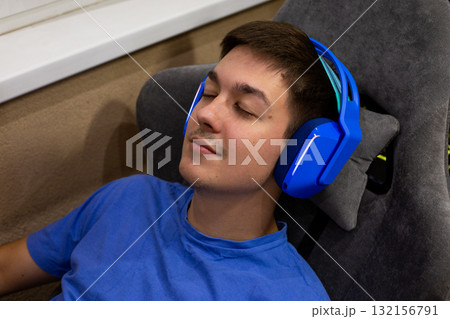 Calm moment where gamer is experiencing pure enjoyment through their headphones. Soft expression and relaxed posture suggest deep, immersive experience in audio entertainment 132156791