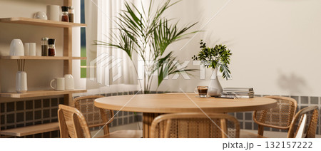 Set of wooden round table and armchairs in dining room or kitchen, with coffee and books placing on. 132157222