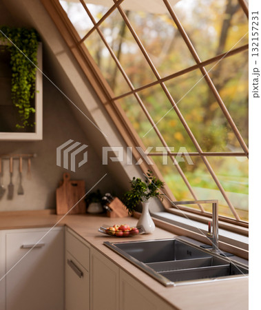 A glass plate with apples on wooden counter with integrated sink under roof window with garden view. A glass plate with apples on wooden counter with integrated sink under roof window with garden view. 132157231