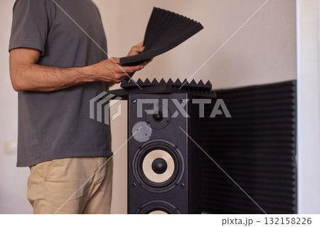 Setting up audio equipment with soundproofing panels in a modern studio environment Setting up audio equipment with soundproofing panels in a modern studio environment 132158226