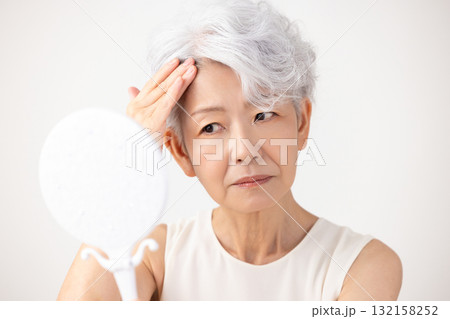シニア女性　生え際を気にするグレイヘアーの女性 132158252