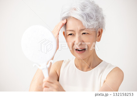 シニア女性　生え際を気にするグレイヘアーの女性 132158253