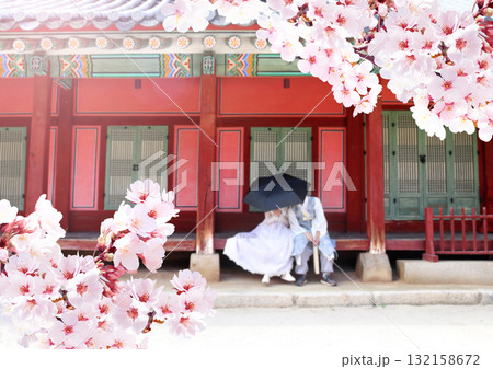 Cherry blossoming season in Republic of Korea. Young boy and girl dressed in traditional dress hanbok and branch of sakura. Tourists in ancient pavilion of Gyeongbokgung Palace, Seoul, South Korea 132158672