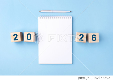 Wooden cubes with numbers for the New Year 2026 with a notebook and pen 132158692