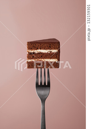 chocolate cake on fork against pink background 132159301