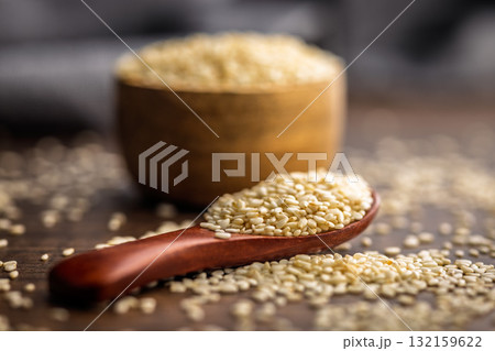 Roasted sesame seeds on spoon on wooden table. 132159622