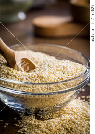 Roasted sesame seeds in bowl on wooden table. 132159625