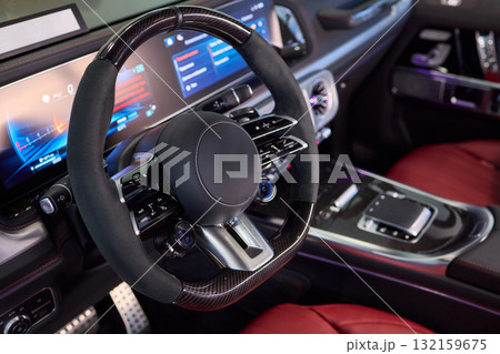 Closeup of a modern car steering wheel with control buttons for technology and convenience Closeup of a modern car steering wheel with control buttons for technology and convenience 132159675