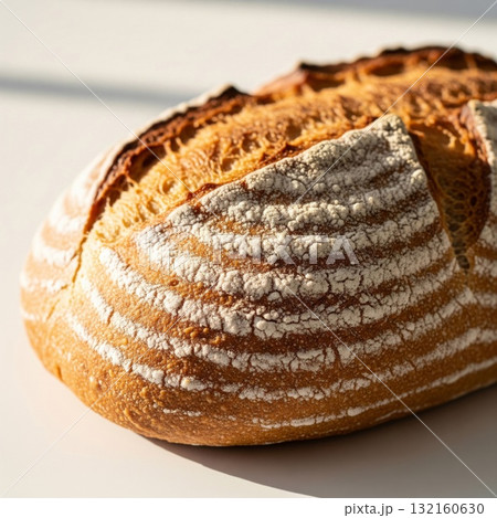 Fresh Baked Sourdough Bread on White Surface in Sunlight 132160630