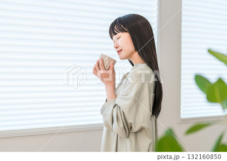 窓辺でホットドリンク,お茶,コーヒーを飲む若いアジア人女性 窓辺でホットドリンク,お茶,コーヒーを飲む若いアジア人女性 132160850