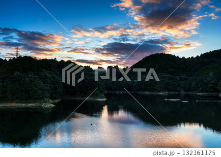 中秋の奈良布目ダム布目湖上空の夕焼け空　黄金色に縁どられた暗雲と布目湖に映る空⑦ 132161175