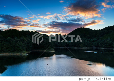 中秋の奈良布目ダム布目湖上空の夕焼け空　黄金色に縁どられた暗雲と布目湖に映る空⑧ 132161176