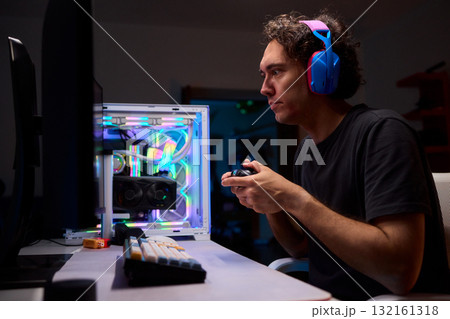 Enjoying an exciting gaming session with a controller and large screen for immersive gameplay Enjoying an exciting gaming session with a controller and large screen for immersive gameplay 132161318