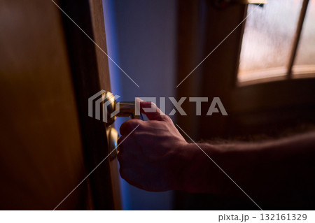 A hand is positioned on the door knob, fully prepared to open the entrance with ease 132161329