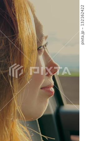Blonde girl, car journey, smiling through window, sunlight reflections, enjoying ride, adventure mood, positive emotions, natural beauty, travel excitement, bright day, Woman looking out of car, smile 132162422