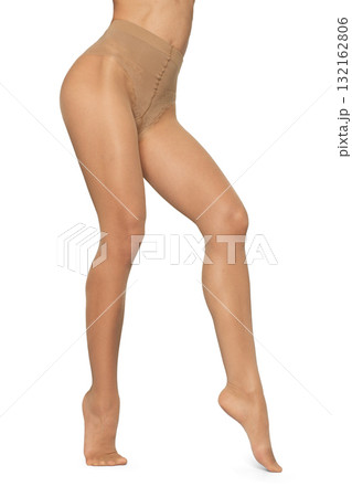 Beautiful long fit female legs in beige tights on white background 132162806
