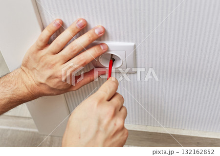 electrician installing electrical wall socket with a screwdriver at home, close-up 132162852