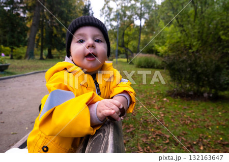 Toddler in Yellow Raincoat Enjoying Park Toddler in Yellow Raincoat Enjoying Park 132163647