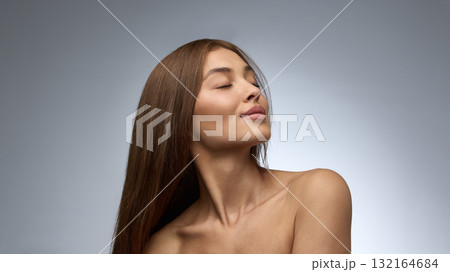 Woman with long straight hair and closed eyes enjoying calm confidence and natural beauty Woman with long straight hair and closed eyes enjoying calm confidence and natural beauty 132164684