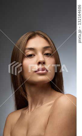 Portrait of young woman with natural skin and confident gaze in beauty concept Portrait of young woman with natural skin and confident gaze in beauty concept 132164686