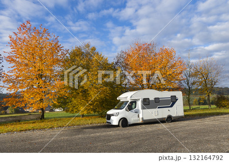 Camper van traveling through colorful autumn foliage in Austria 132164792