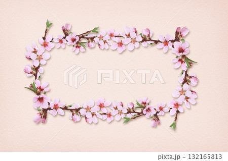 Spring peach twigs in a floral frame on pink paper background. 132165813