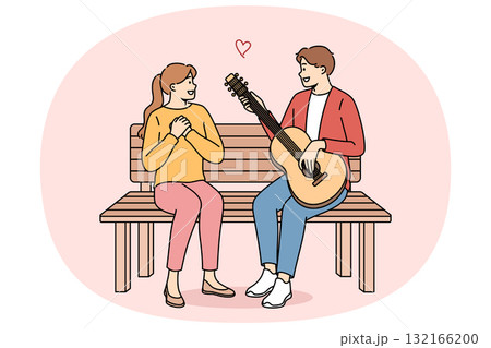 Man sings romantic serenade to woman and plays guitar, sitting on bench during date in park Man sings romantic serenade to woman and plays guitar, sitting on bench during date in park 132166200