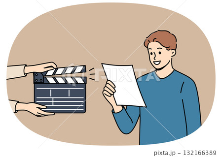 Man actor participates in casting, reading text from piece of paper, standing near clapperboard Man actor participates in casting, reading text from piece of paper, standing near clapperboard 132166389