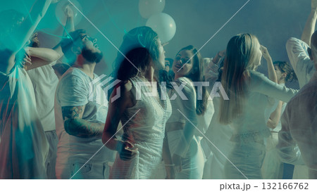 Young adults enjoying dreamy white dance party with glowing lights 132166762