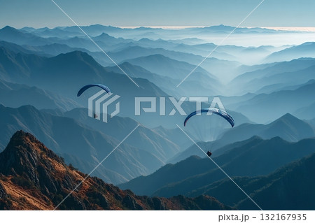 Paragliders flying over majestic mountain range at sunset 132167935
