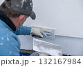 Worker plastering wall facade using hand trowel 132167984