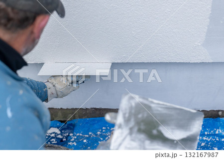 Worker plastering wall with stucco during renovation project Worker plastering wall with stucco during renovation project 132167987