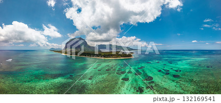 Le Morne Brabant drone panorama over turquoise reef lagoon with sand spit clear sky and dramatic clouds 132169541