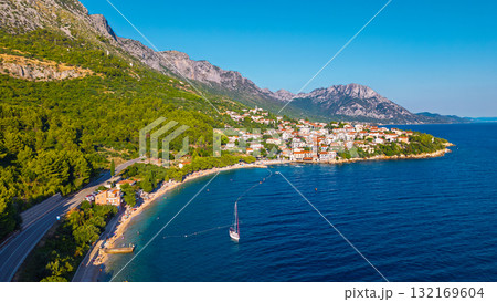Mediterranean hillside settlement overlooking turquoise coves on Makarska Riviera Croatia captured from above during golden hour Mediterranean hillside settlement overlooking turquoise coves on Makarska Riviera Croatia captured from above during golden hour 132169604