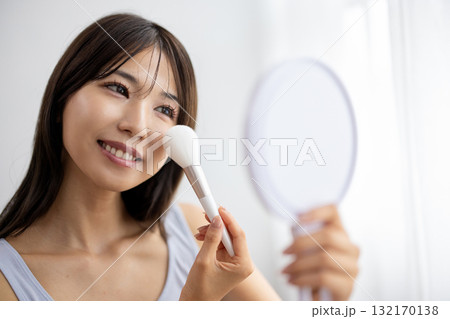 手鏡を見ながらメイクをする若い女性 手鏡を見ながらメイクをする若い女性 132170138