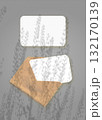 The shadow of field grass falls on an envelope with two sheets of textured white paper on a gray background. Mockup vertical orientation. 132170139
