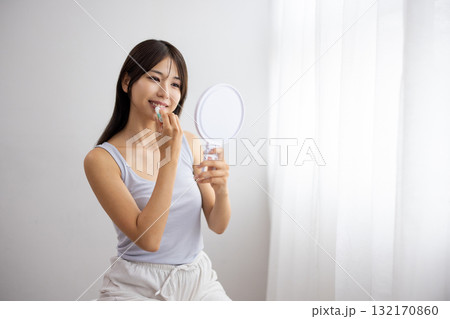 リップクリームを塗る若い女性 132170860