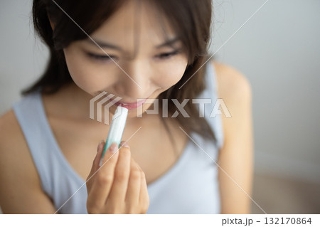 リップクリームを塗る若い女性 132170864