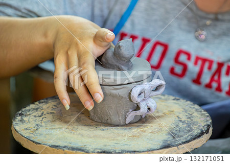 Hand shaping clay pottery in workshop 132171051