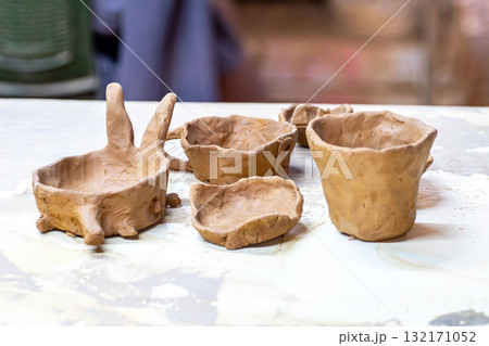 Hand shaping clay pottery in workshop 132171052