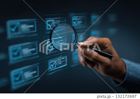 A man's hand holds a magnifying glass over a blue screen with business tasks. 132172697