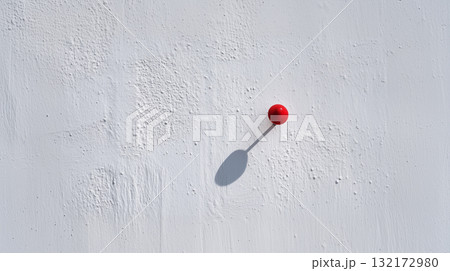 Minimal red pushpin on textured white wall with long shadow and copy space Minimal red pushpin on textured white wall with long shadow and copy space 132172980
