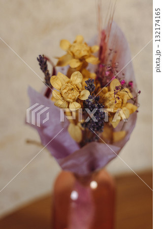 Dried flower bouquet in a glass pink small vase on a table. Dried flowers, wildflowers in a vase, with a soft, blurred background. Boho decor 132174165