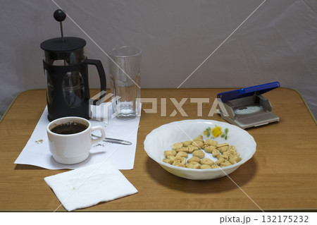 Still life with a coffee press and a hole punch. Still life with a coffee press and a hole punch. 132175232