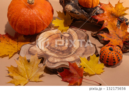 Empty wooden log on table with pumpkin and autumn leaves. Halloween or Thanksgiving display 132175656